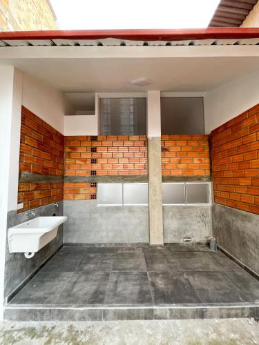 ein Badezimmer mit einem Waschbecken und einer Ziegelwand in der Unterkunft Mono ambiente comfortable in Moyobamba