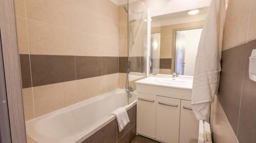 une salle de bain avec une baignoire et un lavabo et une baignoire dans l'établissement Mini-villa alliance wifi proche ile rousse, à Belgodère