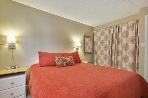 a bedroom with a bed with a red comforter at Tannhauser 225 in Breckenridge