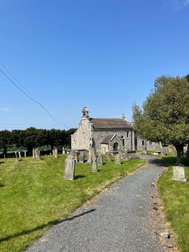 an old stone building with a cemetery in front at Ellerton Lodge Bed and Breakfast Swaledale in Richmond