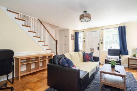 a living room with a couch and a staircase at Spacious 4BR CozySuites in Old Town Alexandria in Alexandria