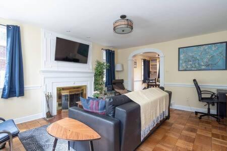 a living room with a couch and a fireplace at Spacious 4BR CozySuites in Old Town Alexandria in Alexandria