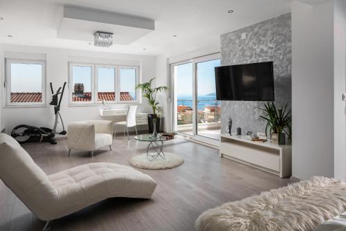 a living room with a couch and a tv on a wall at Villa Palladium in Makarska