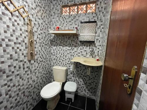 La petite salle de bains est pourvue de toilettes et d'un lavabo. dans l'établissement Casa Dona Van Van Praia do Francês, à Marechal Deodoro