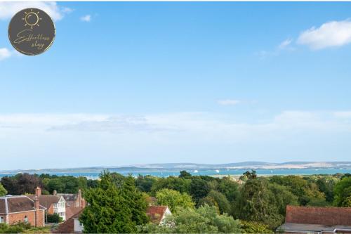 een uitzicht vanaf het dak van een huis met bomen bij Leeward House - Luxury, Spacious, Sea View Apartment, Parking, Central Lymington in Lymington
