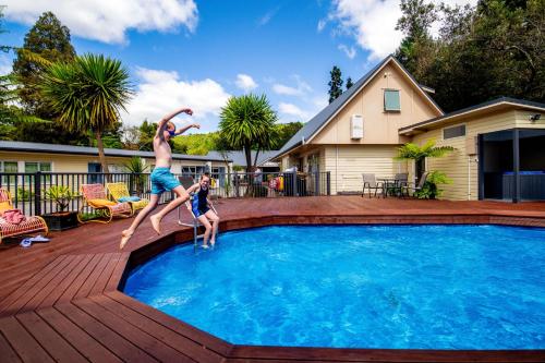 a man and a child jumping into a swimming pool at Ripple Rotorua in Rotorua