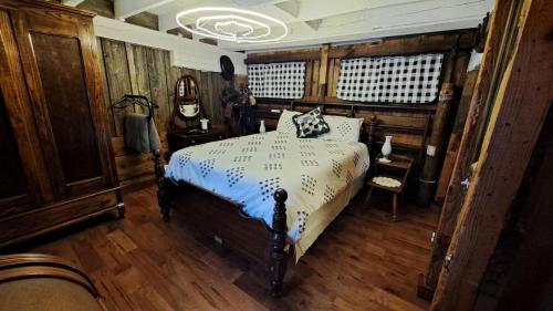 a bedroom with a bed in a room with wooden floors at The Stable at Windmill Ridge Farm in Fredonia
