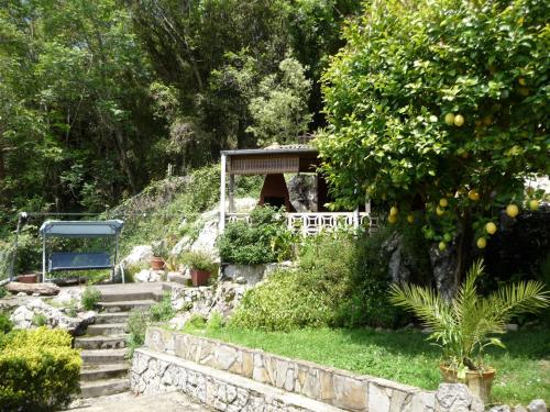 a garden with a gazebo and an orange tree at Casa Molily in Llanes