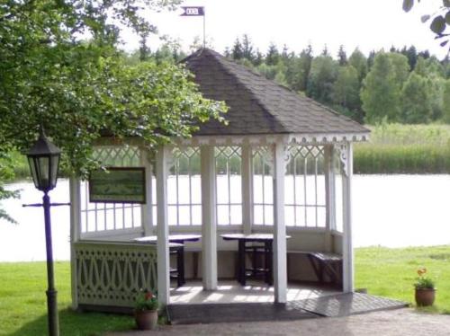 a white gazebo with a table and a street light at STF Långasjö Vandrarhem in Långasjö