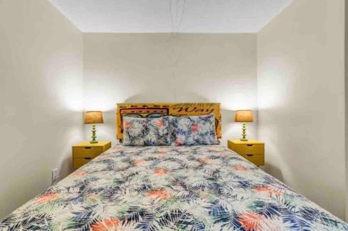a bedroom with a large bed with two lamps at Sea La Vie on the Boardwalk in Carolina Beach
