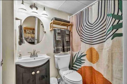 a bathroom with a sink and a toilet and a mirror at Sea La Vie on the Boardwalk in Carolina Beach