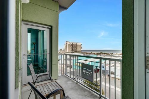 a balcony with two chairs and a view of the beach at Beach Views on Cape Fear in Carolina Beach