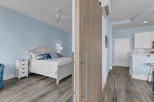 a bedroom with a white bed and wooden floors at Beach Views on Cape Fear in Carolina Beach