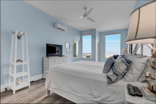 a bedroom with a white bed with a view of the ocean at Beach Views on Cape Fear in Carolina Beach
