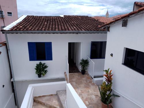 Cette chambre offre une vue sur une maison blanche dotée de fenêtres bleues. dans l'établissement Pousada Três Marias Cachoeira Paulista, à Cachoeira Paulista