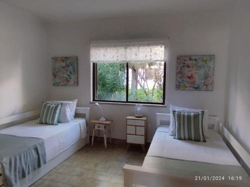 1 dormitorio con 2 camas y ventana en SAO RAFAEL TRADICIONAL BEACH APARTMENT, en Albufeira