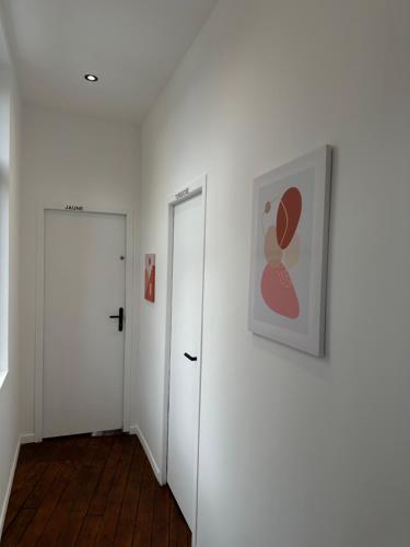 un pasillo con dos puertas y una pintura en la pared en La chambre jaune, en Amiens