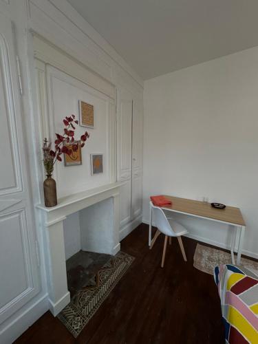 sala de estar con escritorio y chimenea en La chambre jaune, en Amiens