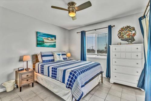 a bedroom with a bed and a ceiling fan at Seas The Day with Fantastic Marina Views in Carolina Beach