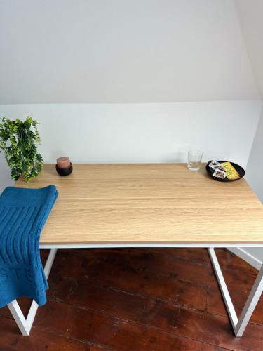 una mesa de madera con una silla azul junto a ella en La chambre bleue, en Amiens