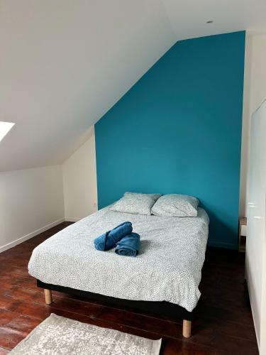1 dormitorio con 1 cama con pared azul en La chambre bleue, en Amiens