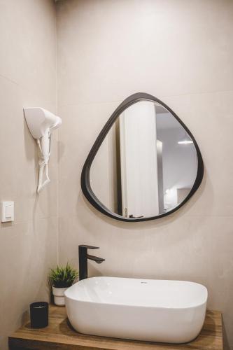 a bathroom with a white sink and a mirror at Votsalo Tolo in Tolo