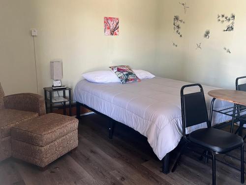 Midtown Inn & Suites في La Junta: غرفة نوم بسرير وطاولة وكرسي
