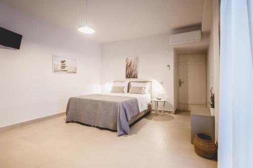 a bedroom with a bed in a white room at Votsalo Tolo in Tolo