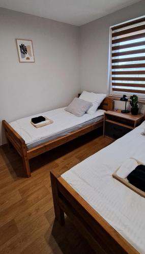 a bedroom with two twin beds and a window at Noclegi u Lidki 