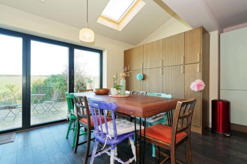 a dining room with a wooden table and chairs at Kent Downs Cottage Modern Family Retreat near Canterbury in Canterbury