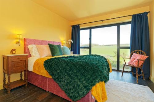 a bedroom with a bed and a large window at Kent Downs Cottage Modern Family Retreat near Canterbury in Canterbury