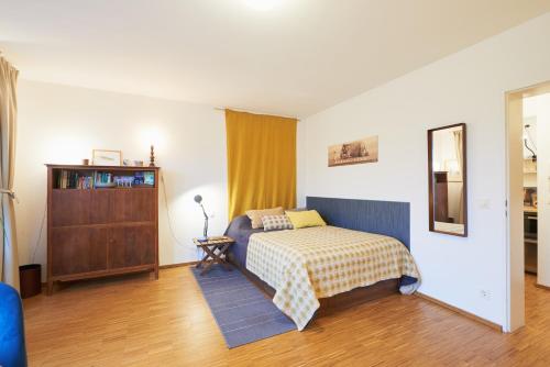 a bedroom with a bed and a dresser at Explorer Apartment Düsseldorf in Düsseldorf