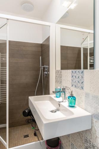 a bathroom with a white sink and a shower at Terrazza Dei Sogni in Ragusa