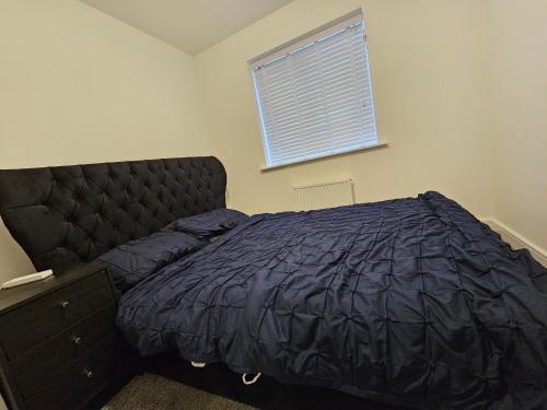 a bedroom with a black bed and a window at guest room in crewe in Church Coppenhall