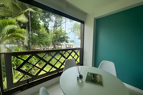 a room with a table and a large window at Lindo apto no Condomínio Enseada Praia do Forte in Mata de Sao Joao