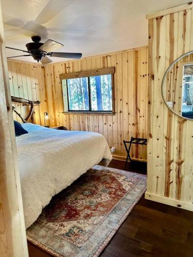 a bedroom with a bed in a room with wooden walls at Cozy Cabin Retreat in Ponderosa