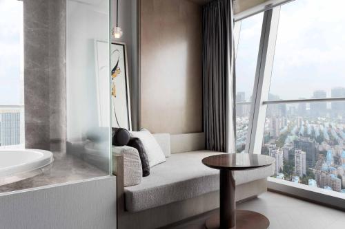 uma casa de banho com uma banheira, um lavatório e uma janela em JW Marriott Marquis Hotel Shanghai Pudong em Xangai
