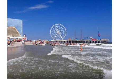 a beach with a ferris wheel in the background at CozySuites at Showboat Bold 2BR 3BA Beachfront in Atlantic City