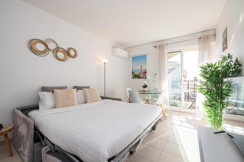 une chambre avec un grand lit et un balcon dans l'établissement St.Roch : vue mer, parking, clim, à Menton