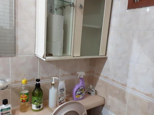 lavabo con botellas de jabón y espejo en Camp Humphreys pyeongtaek's sharing house, en Pyeongtaek