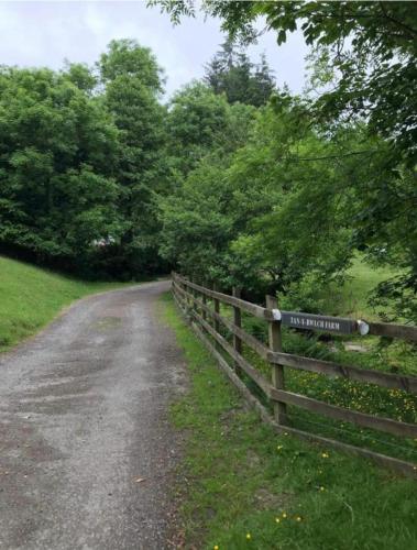 a fence with a sign on it next to a road at The Lodge in Llangollen