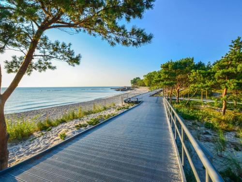 a boardwalk leading down to the beach at Comfortable 4-person cottages, Ustronie Morskie in Ustronie Morskie