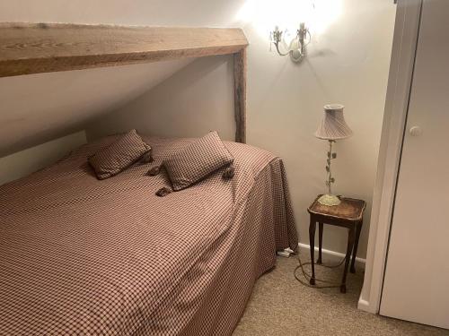 a bedroom with a bed with a checkered blanket at The Plover in Blakeney