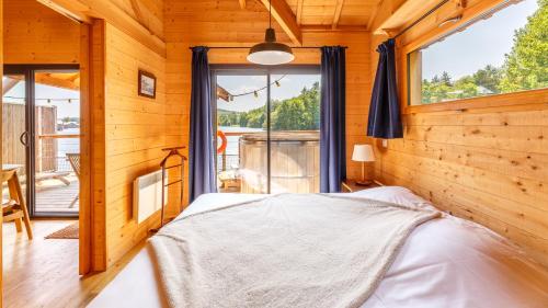 - une chambre avec un lit et une grande fenêtre dans l'établissement Lieu Dieu, Domaine de Campagne, à Beauchamps