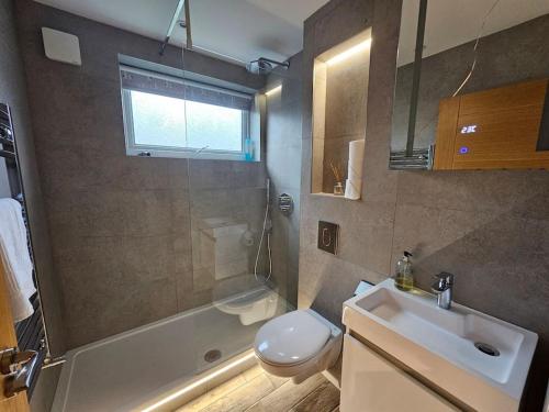 y baño con lavabo, aseo y ducha. en Neon Heights 2 bed Luton town centre en Luton