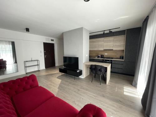 uma sala de estar com um sofá vermelho e uma cozinha em New Level Up Building in Bucharest em Bucareste