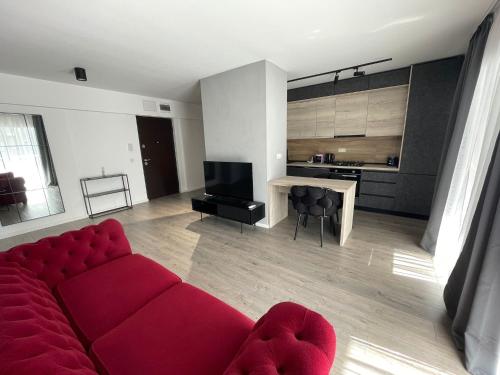 uma sala de estar com um sofá vermelho e uma cozinha em New Level Up Building in Bucharest em Bucareste