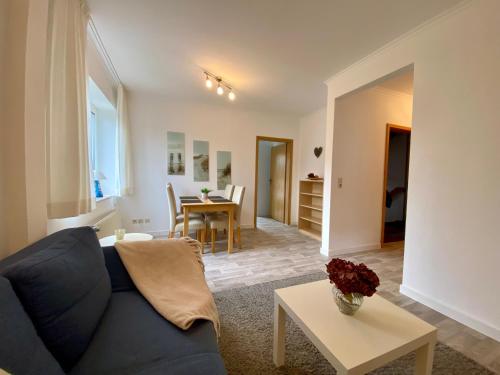 a living room with a blue couch and a table at Haus Nicole in Cuxhaven