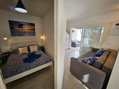 a bedroom with a bed and a couch in a room at Apartamento TAISA Playa Roca in Costa Teguise