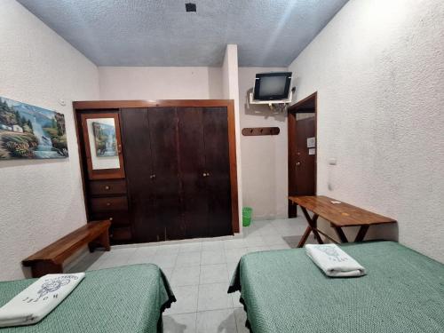 Habitación con 2 camas, mesa y TV. en HOTEL CARMELITAS 42 en Villahermosa
